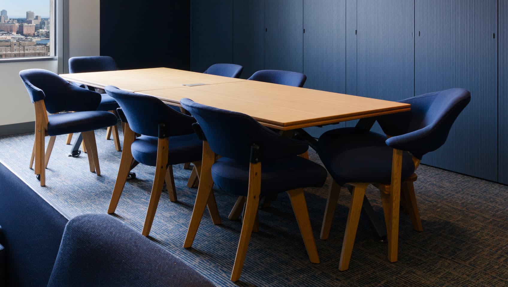Small professional conference room in a Bergen County law office with a rectangular wood table and cool natural sidelight