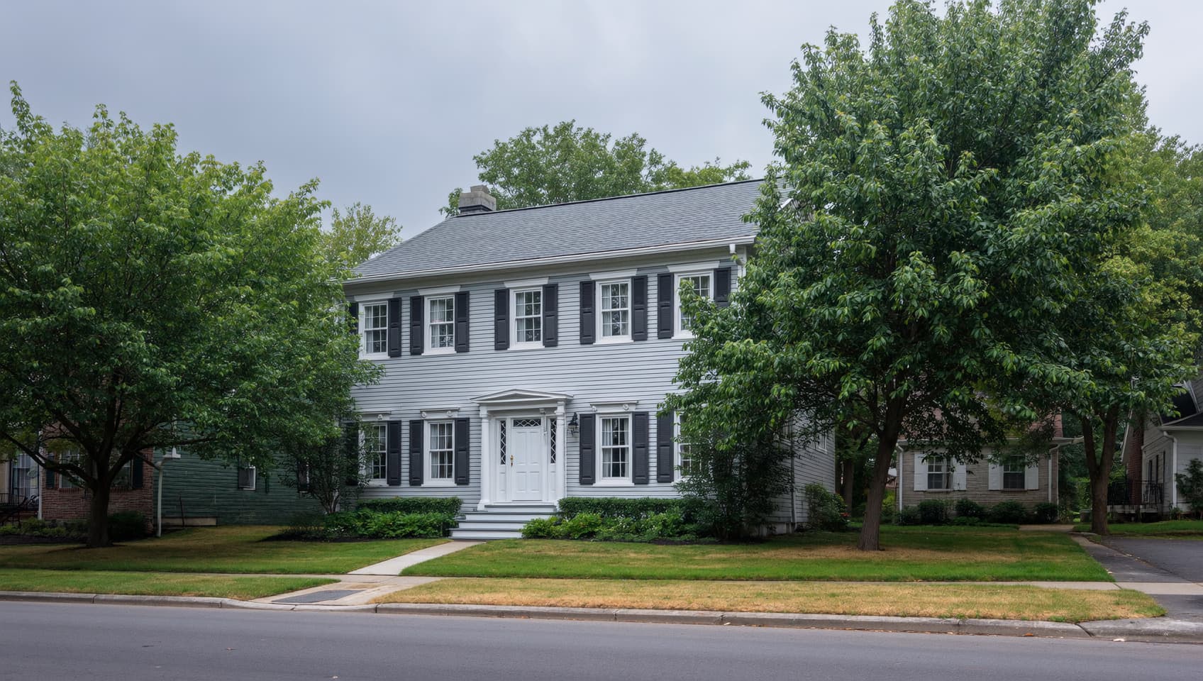 Classic colonial home on a quiet suburban New Jersey street under overcast mid-morning light